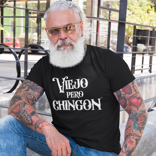 Older Man with White Hair and Tattoos wearing a black shirt with white text that says Viejo Pero Chingon