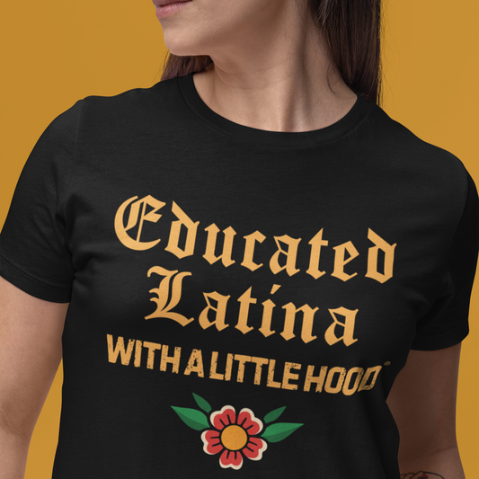 Person wearing a black t-shirt with 'Educated Latina with a Little Hood' text and a flower graphic on a yellow background