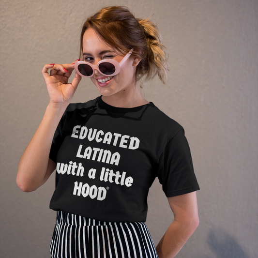 Woman wearing a Black t-shirt with white text 'EDUCATED LATINA with a little HOOD' against a plain background